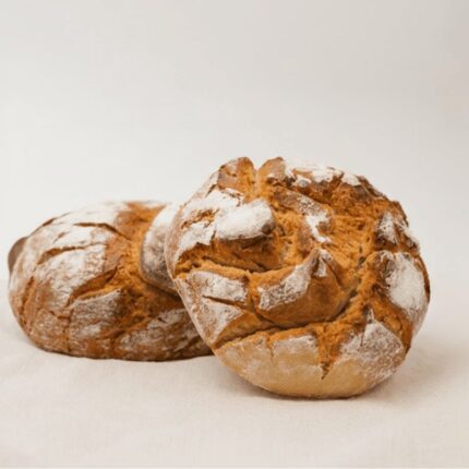 Duas broas de milho em cima uma da outra em cima de mesa de pano