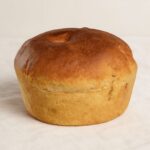 Folar Transmontano com crosta dourada e disposto num pano branco