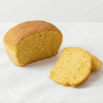 Um pão amarelado apresentado fatiado