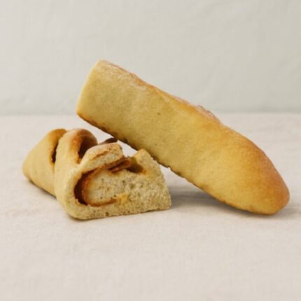 Duas metades cortadas de pão com chouriço numa toalha de pano