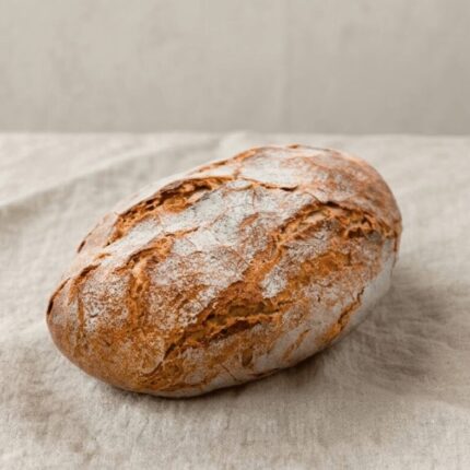 Pão de Centeio com crosta dourada colocado em cima de toalha de pano