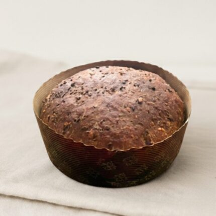 Bôla com forma de papel castanho escuro em cima de toalha de pano branca